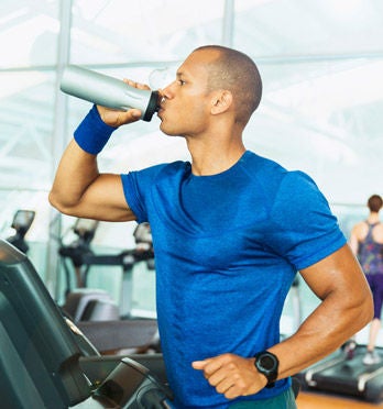 Hombre tomando agua y haciendo ejercicio 